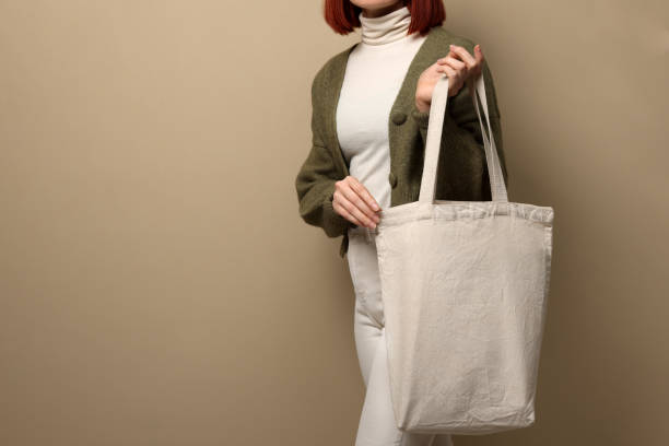 istock Woman with eco bag on beige background, closeup. Space for text 1451001294
