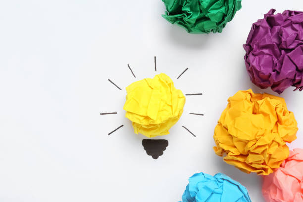 istock Flat lay composition with yellow crumpled paper ball as lamp bulb on white background, space for text. Idea concept 1451001680