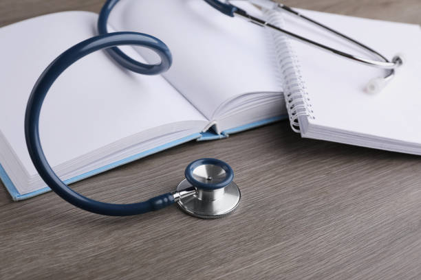 istock Book, stethoscope and notebook on wooden table. Medical education 1451001906