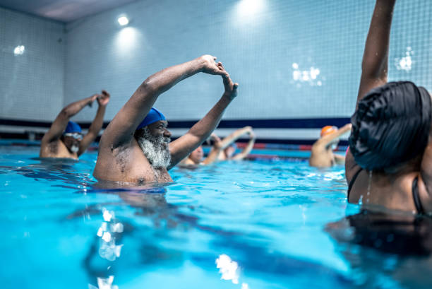 istock Senior people stretching at swimming pool 1451002122