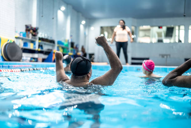 istock Disabled senior man exercising at swimming pool 1451002171