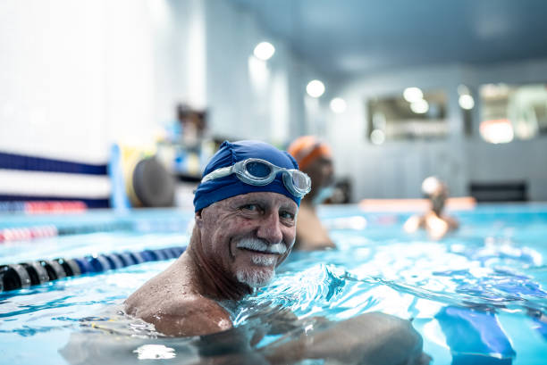 porträt eines älteren mannes im schwimmbad - active seniors retirement enjoyment swimming pool stock-fotos und bilder