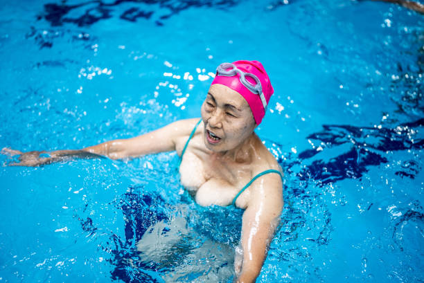 istock Senior woman exercising at swimming pool 1451002685