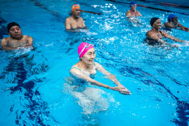 istock Senior people exercising at swimming pool 1451002696