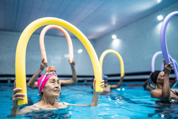 istock Senior people exercising with noodle float at swimming pool 1451003190