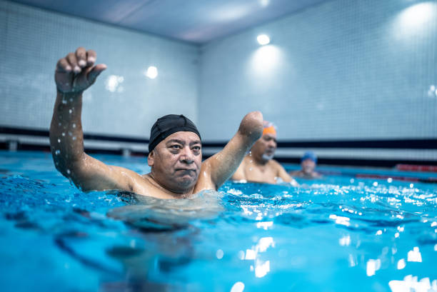 istock Disabled senior man exercising at swimming pool 1451003206