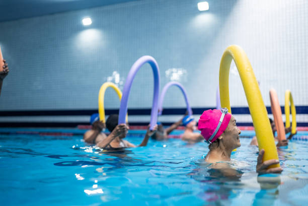 istock Senior people exercising with noodle float at swimming pool 1451003446