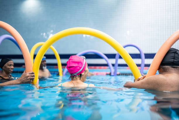 istock Senior people exercising with noodle float at swimming pool 1451003484