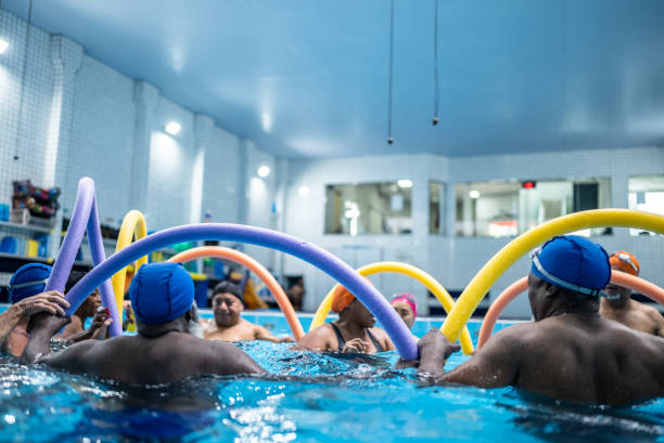 istock Senior people exercising with noodle float at swimming pool 1451003550