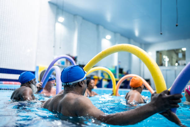 istock Senior people exercising with noodle float at swimming pool 1451003567