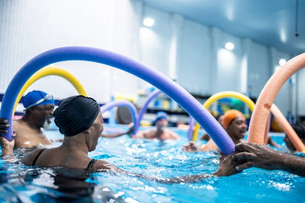 istock Senior people exercising with noodle float at swimming pool 1451003577