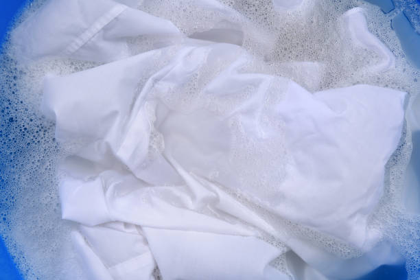 istock White garment in suds, closeup. Hand washing laundry 1451005086