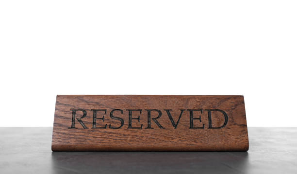 istock Elegant wooden sign Reserved on grey table against white background 1451005233