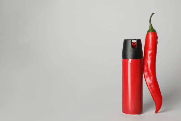 istock Bottle of gas spray and fresh chili pepper on light grey background. Space for text 1451005464