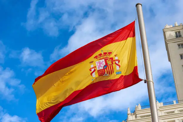 Close-up of a Spanish flag blowing in the wind in Spain Square (Plaza de Espana), Madrid downtown, Spain, southern Europe.