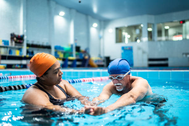 istock Senior man learning to swim in a swimming pool 1451008139