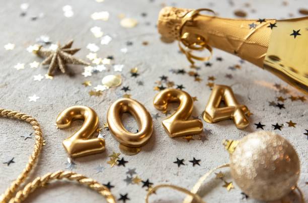 Golden 2024 new year numbers with confetti and champagne bottle Golden color palette photo with new year 2024 numbers surrounded by confetti and decorations new years eve stock pictures, royalty-free photos & images