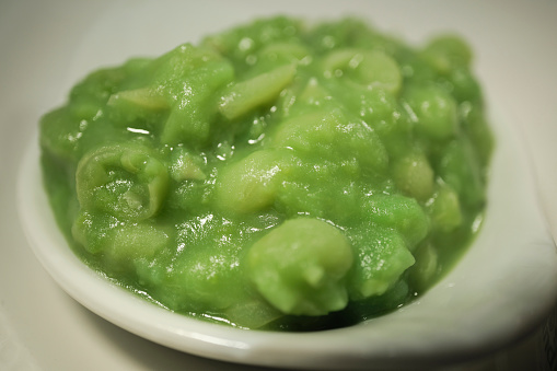 Close up of a dish filled with Mush Peas.