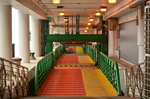 Hong Kong,China, December 23rd 2019. Bright colours on the gangway leading to a ferry on Hong Kong's central pier.