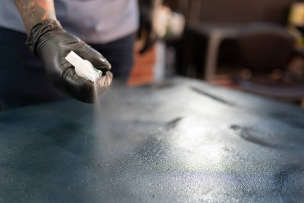 istock A tattoo artist is cleaning the studio stretcher with a spray 1451021503