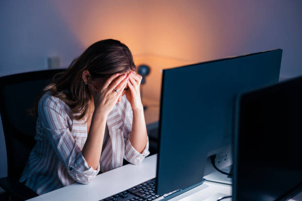 istock Stressed out woman working late in an office 1451021708