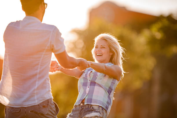 istock Carefree couple having fun while spinning in the park. 1451022742