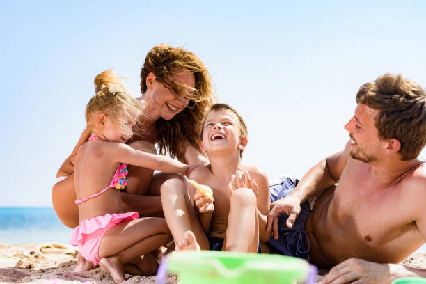 istock Happy parents and their small kids having fun on the beach. 1451026084