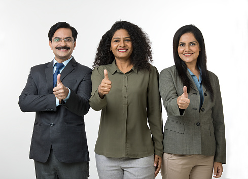 Portrait of cheerful businessman and businesswomen showing thumbs up
