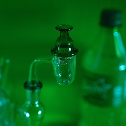 A closeup of a glass smoking banger on blur green background