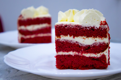 Red velvet cake with cream for Valentine's Day. Two pieces of cake on a wooden table
