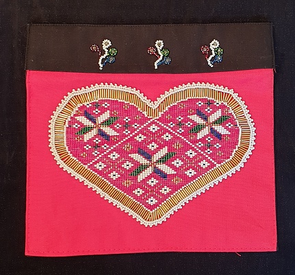 Part of the traditional Norwegian women's costume. Handmade by embroidering or weaving with beads.