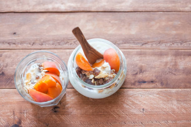 oatmeal with candied fruits, raisins in a plate on a wooden table.
