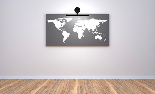 3d render illustration of the empty modern room with gray wall and wooden floor, the picture of the world map on the wall with one light point. Clean new office place with gray wall, world map and wooden floor.