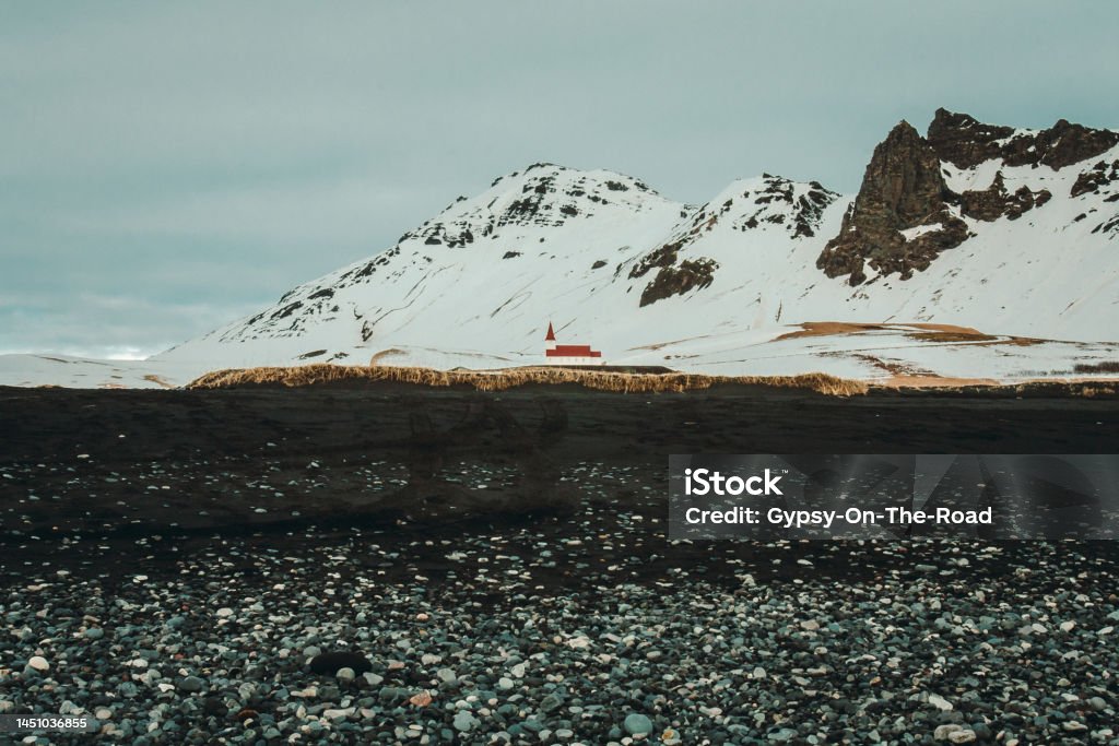 Reyniskirkja church near mountain landscape photo Reyniskirkja church near mountain landscape photo. Beautiful nature scenery photography with cloudy sky on background. Idyllic scene. High quality picture for wallpaper, travel blog, magazine, article Architecture Stock Photo