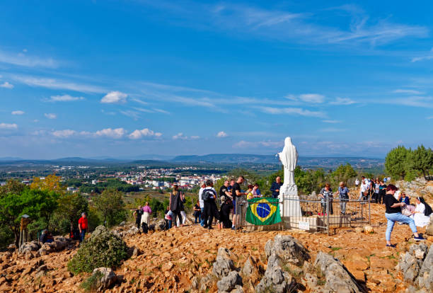 Medjugorje, Bosnia and Herzegovina – Oct 14, 2022: Statue of Virgin Maria in Medjugorje surrounded by pilgrims.