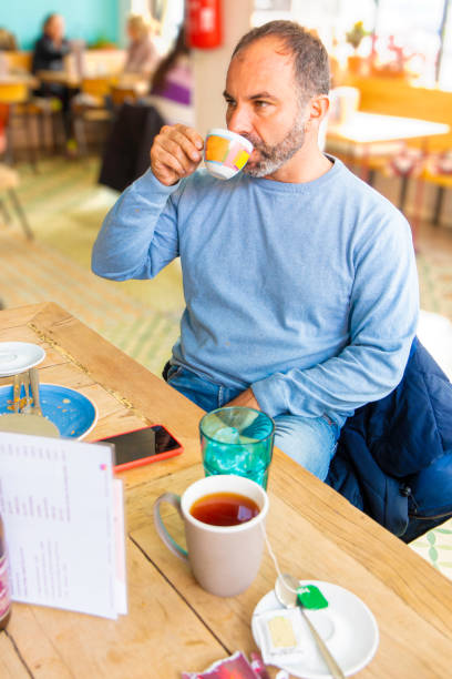 istock adult man with beard drinks from a colored coffee cup in a modern cafeteria 1451037466