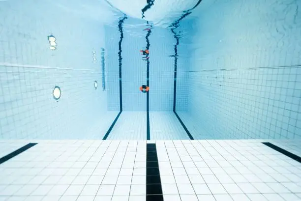 A human diving in a clear and well-designed pool