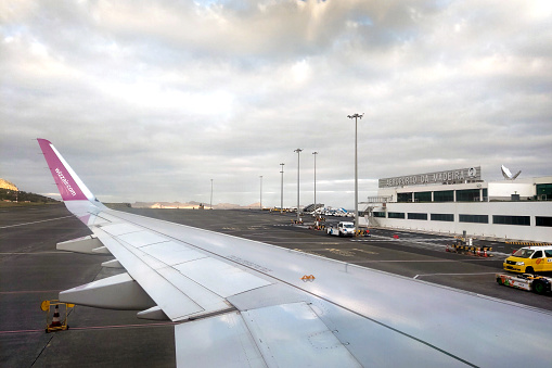 Madeira, Portugal, November 22, 2022: View from the airplane window to Funchal Airport, Madeira, Portugal. Funchal Airport runway landscape. Cristiano Ronaldo International Airport in Madeira