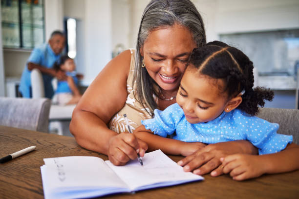 Learning, writing and notebook with grandma and girl for education, study and family help with homework. Care, love and idea with child and old woman and book for teaching, student and remote work