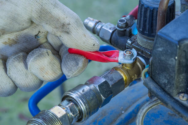 istock technician hand holding air compressor control valve, red valve. 1451047750