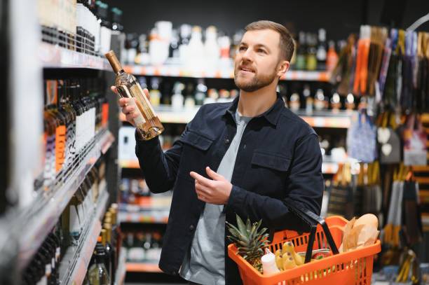 istock Man in a supermarket choosing a wine 1451049067