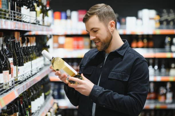 istock Man in a supermarket choosing a wine 1451049092