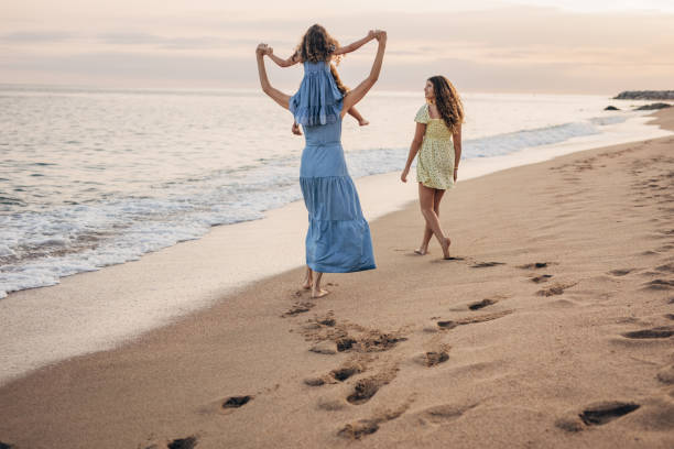istock Mom and daughters by the sea 1451055683