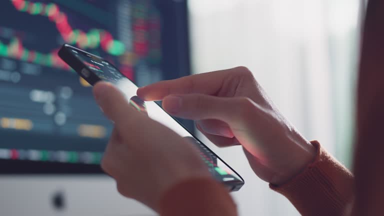 Woman is checking Bitcoin price chart on digital exchange on smartphone, cryptocurrency future price action prediction.