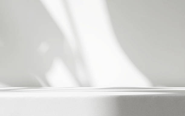 table counter with white linen tablecloth drape in sunlight, smooth leaf shadow on wall with space in background - pedestal imagens e fotografias de stock