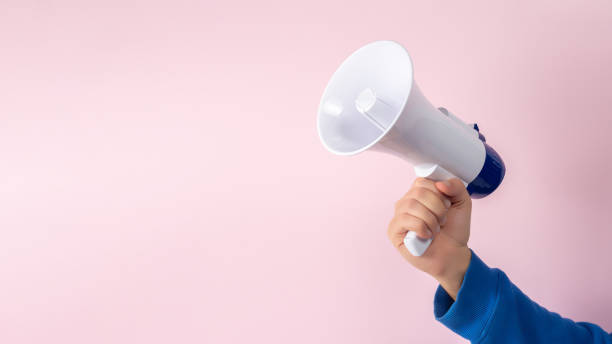 istock Man's hand with megaphone on pink background. Minimal advertising background. 1451064086