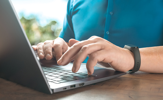 Close up of person hand typing on laptop keyboard, author writing on notebook computer, businessman programmer working concept. Freelancer copywriter working project, typing text, edit