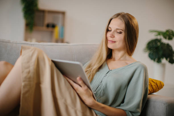 istock A girl sitting with a tablet and a stylus on the couch 1451066714