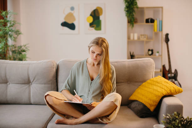 istock Happy young designer drawing on a graphics tablet with a stylus pen. Creative young freelancer working in her home office. 1451066949