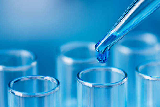istock Test tubes with blue liquid water samples and pipette over blue background. 1451068460